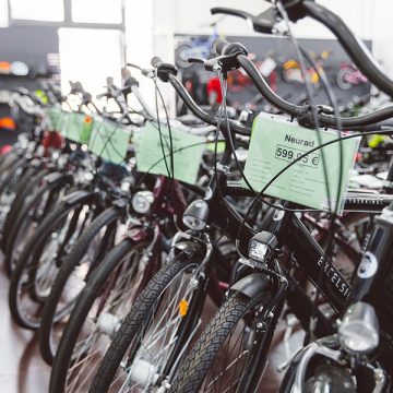 Mehrere Neuräder mit grünen Preisschildern stehen in dem Ladengeschäft von FahrRad R18 in München zum Verkauf bereit.