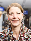 Mitarbeitendenporträt von Stefanie Göppl bei FahrRad R18 in München - Eine lächelnde Frau mit locker gemustertem Hemd blick in die Kamera