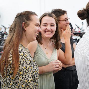 Zwei junge Frauen in Kleidern bei der Eröffnungsfeier von FahrRad R18 in München. Beide lachen.